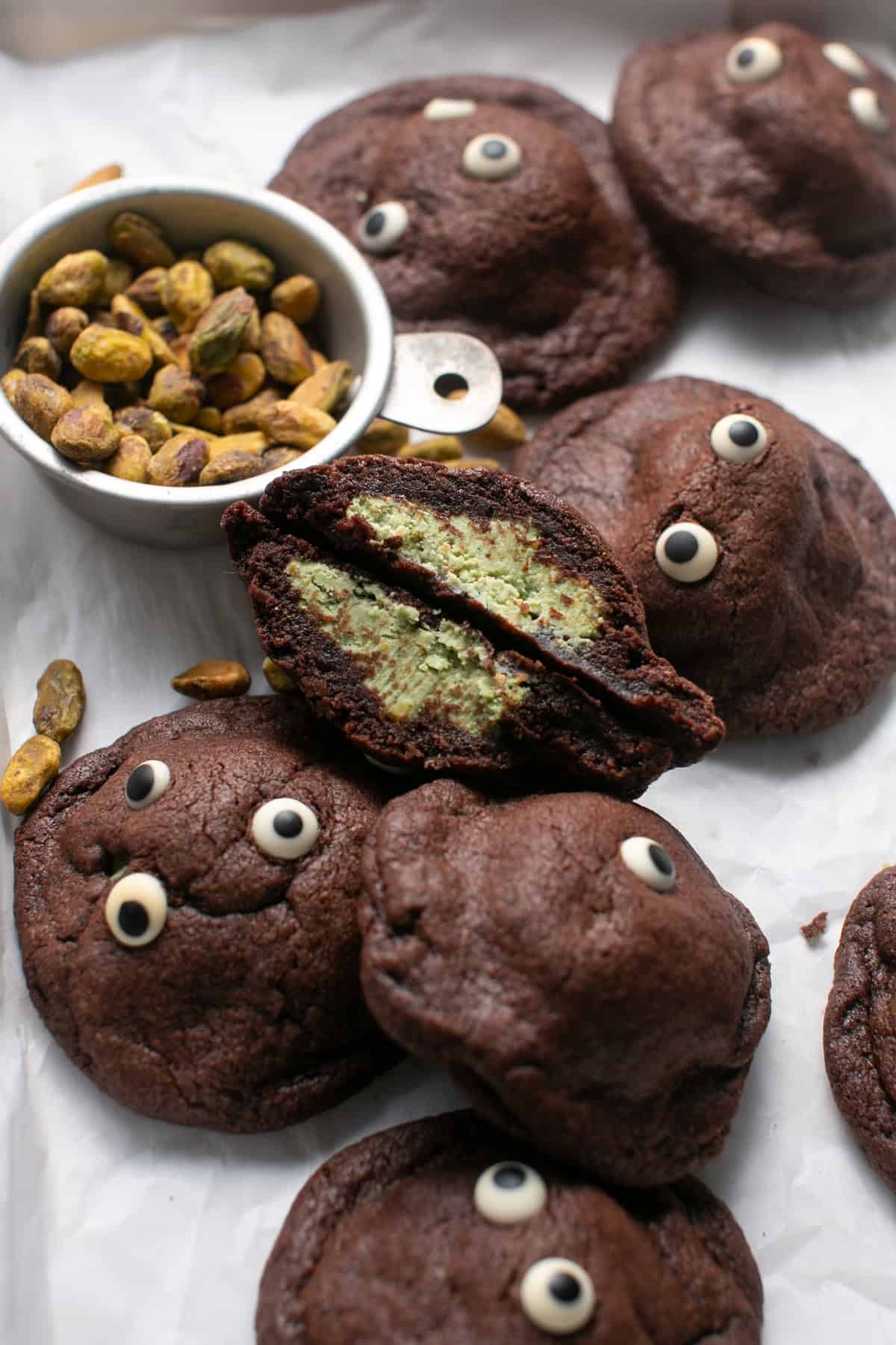 White Chocolate Pistachio Stuffed Cookie Recipe broken in half on a sheet tray.