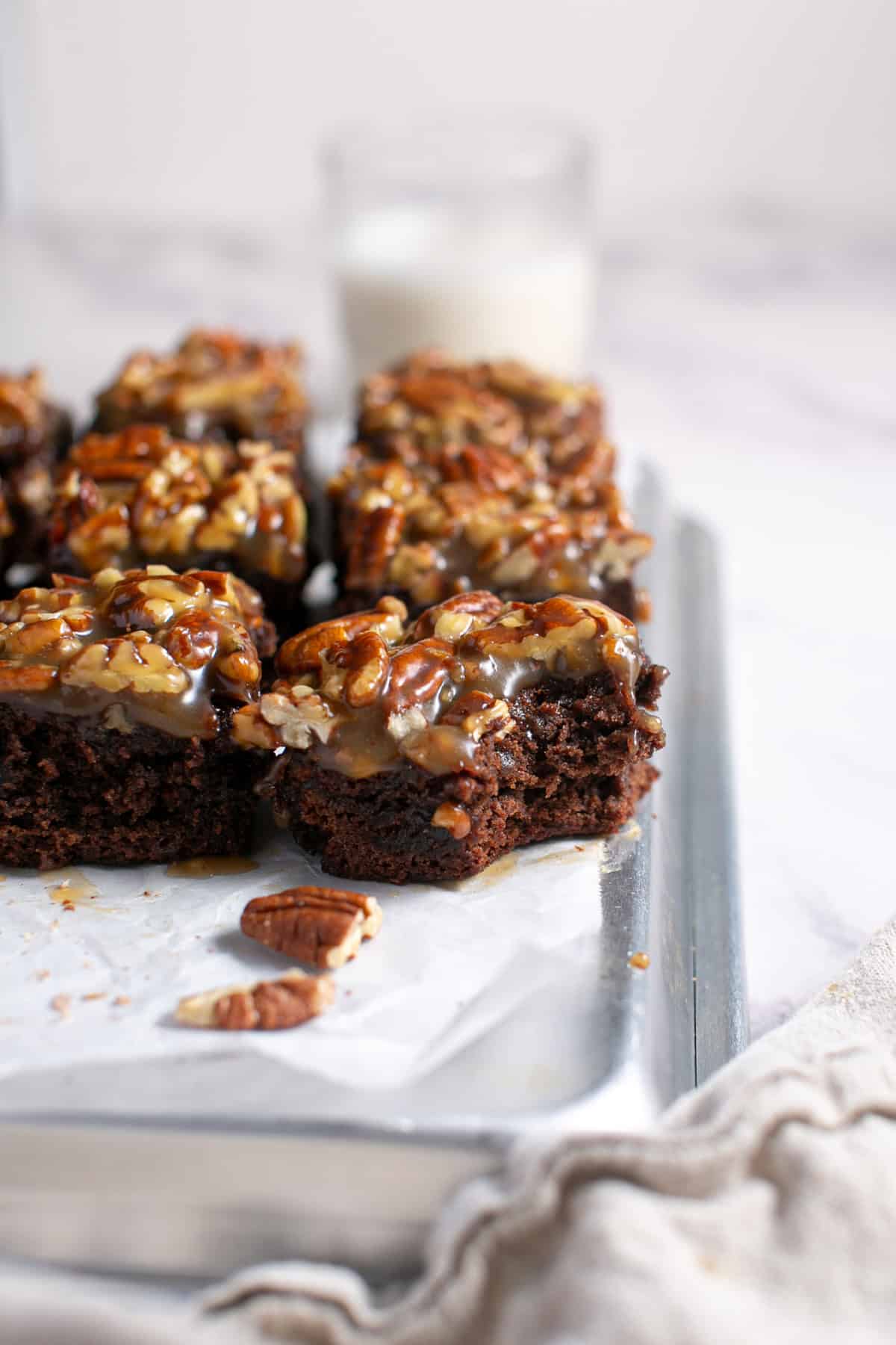 Pecan Pie Brownies sitting by a bowl of pecans.