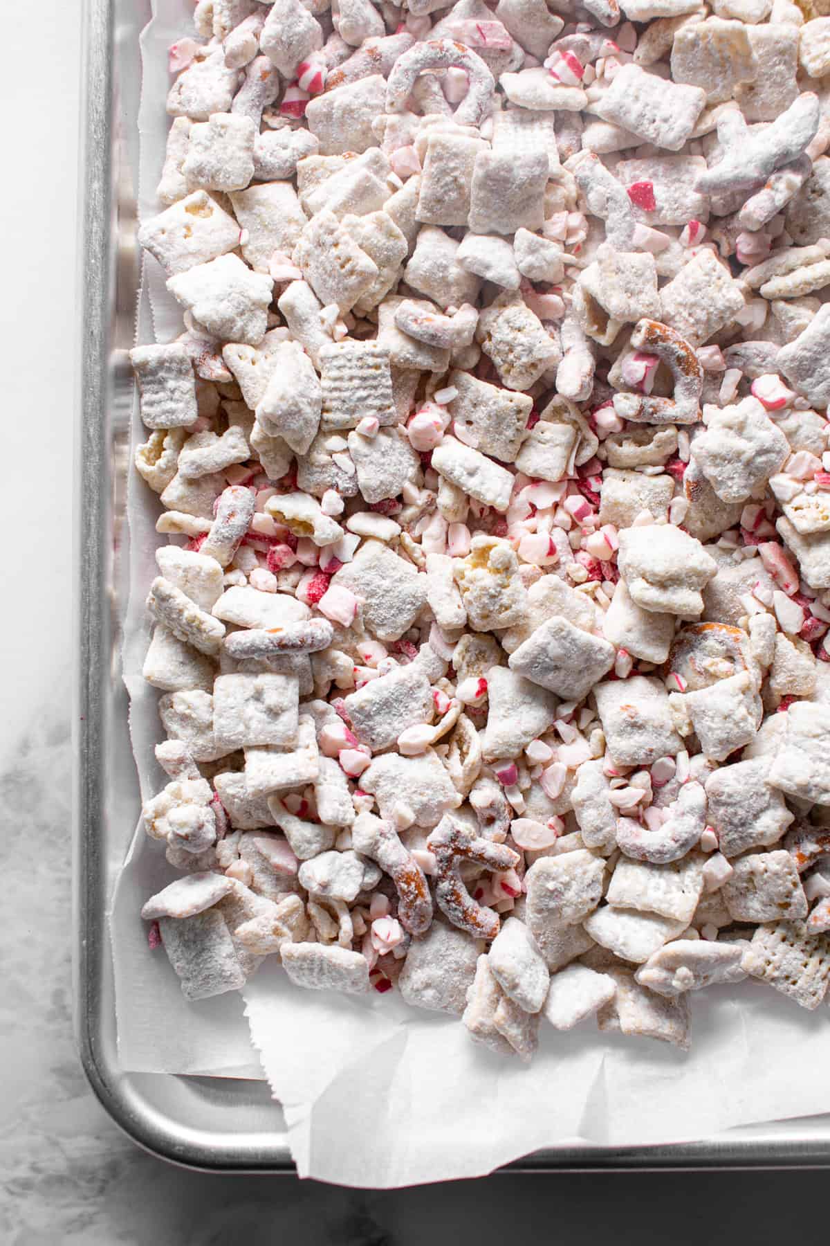 White Chocolate Peppermint Puppy Chow on a sheet pan to set. 