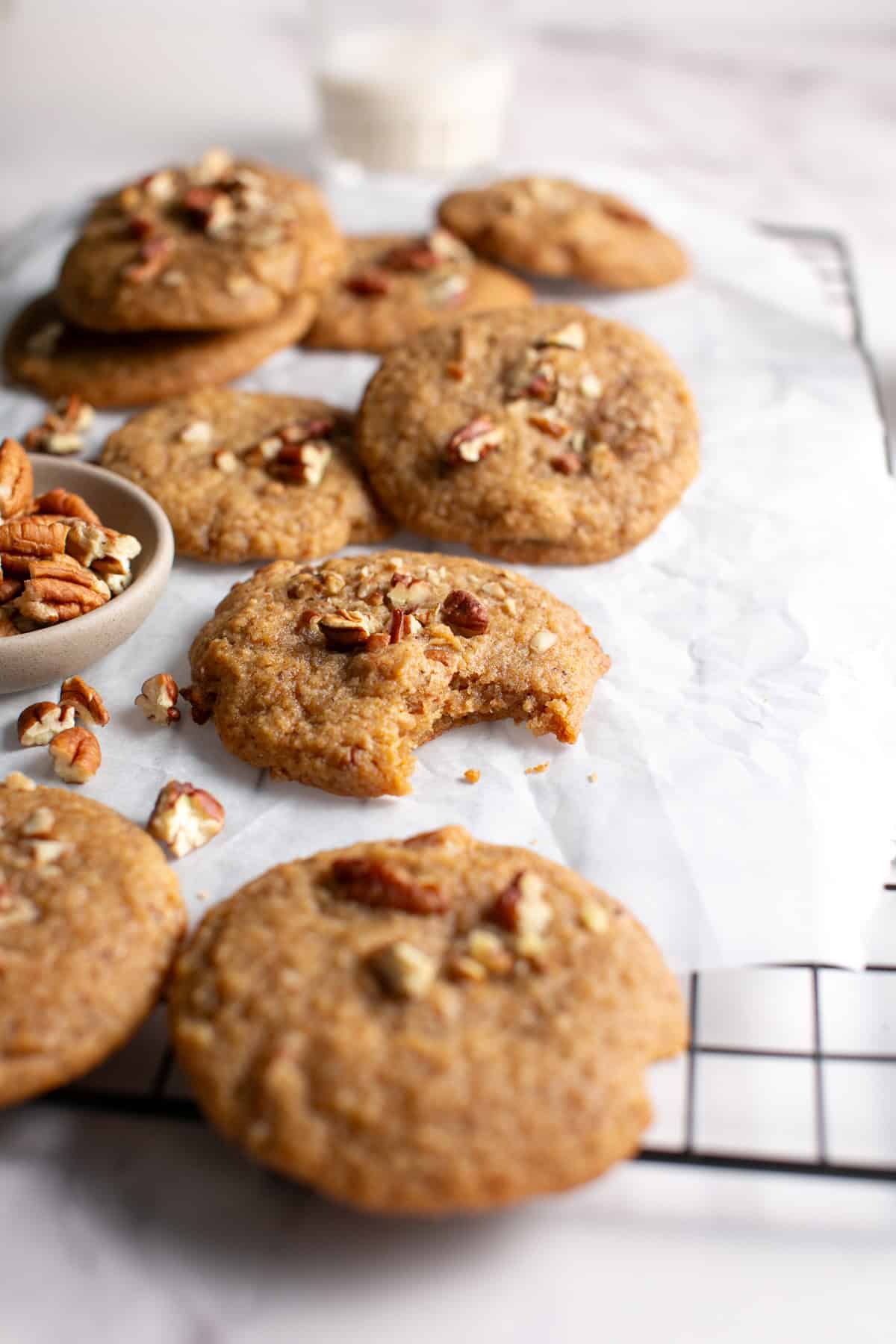 Brown Butter Apple Butter Cookies with Pecans with a bite missing on parchment paper. 