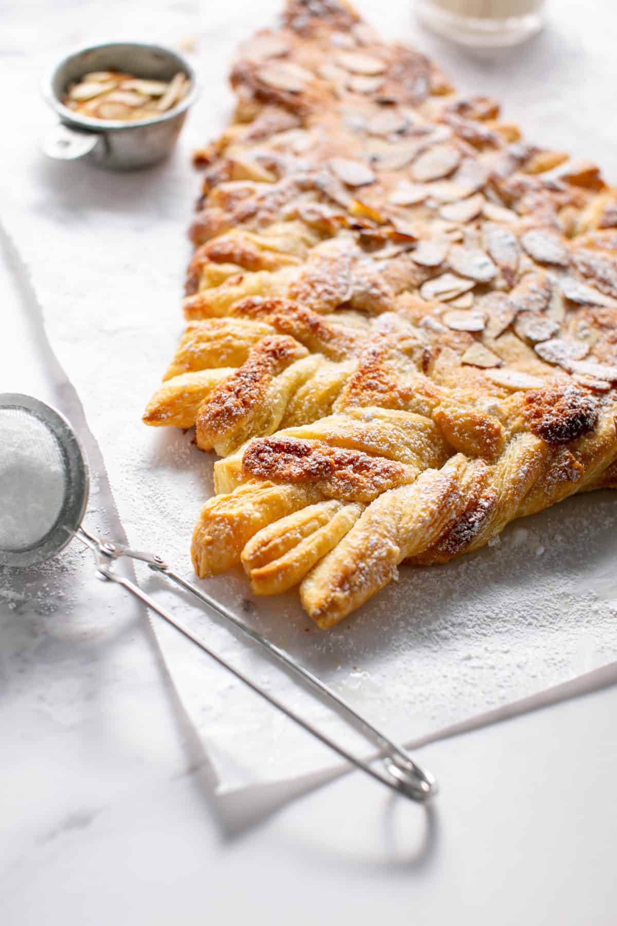 Almond Croissant Puff Pastry Christmas Tree with powdered sugar on top.