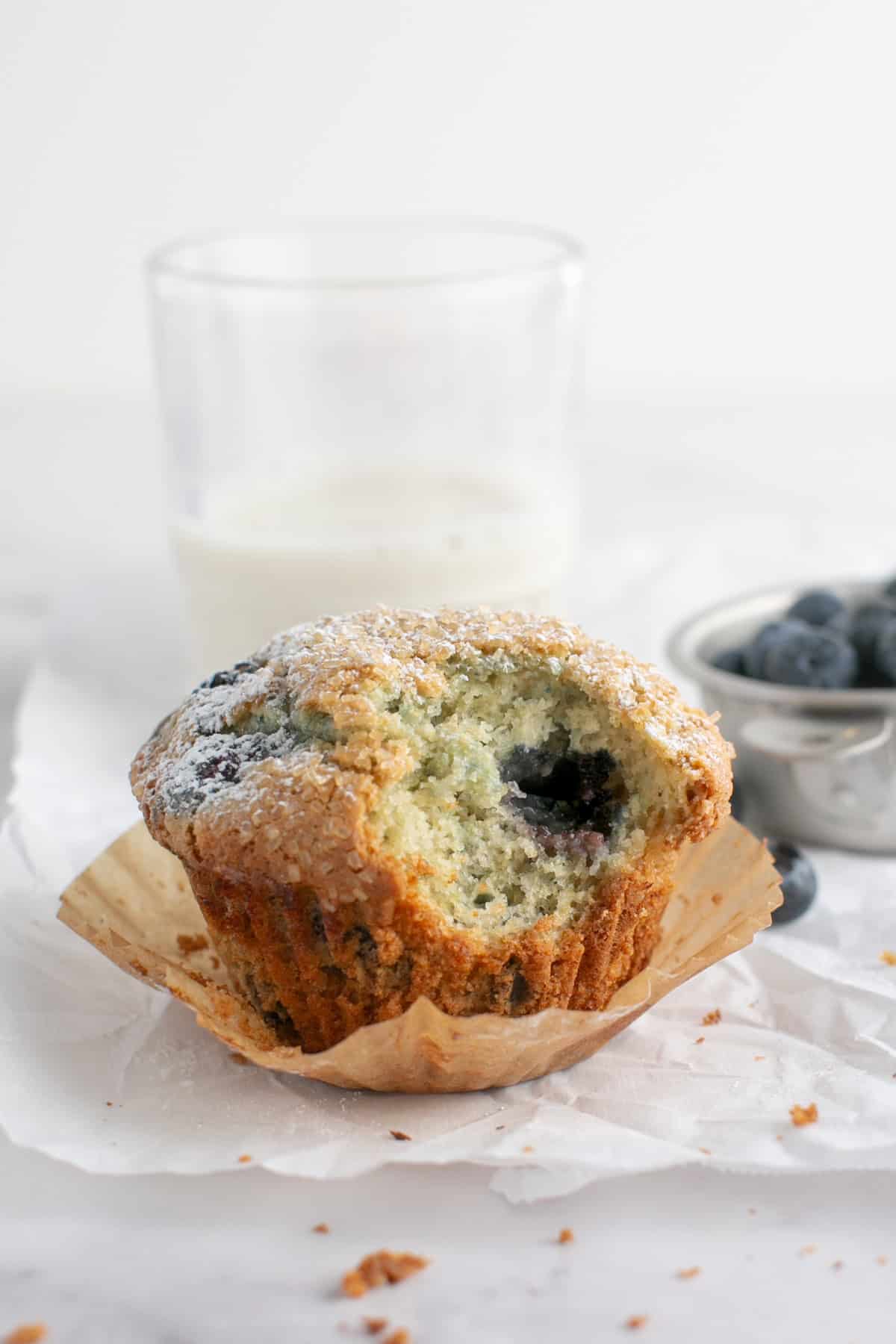 Single Serve Blueberry Muffin with a bite missing by some blueberries. 