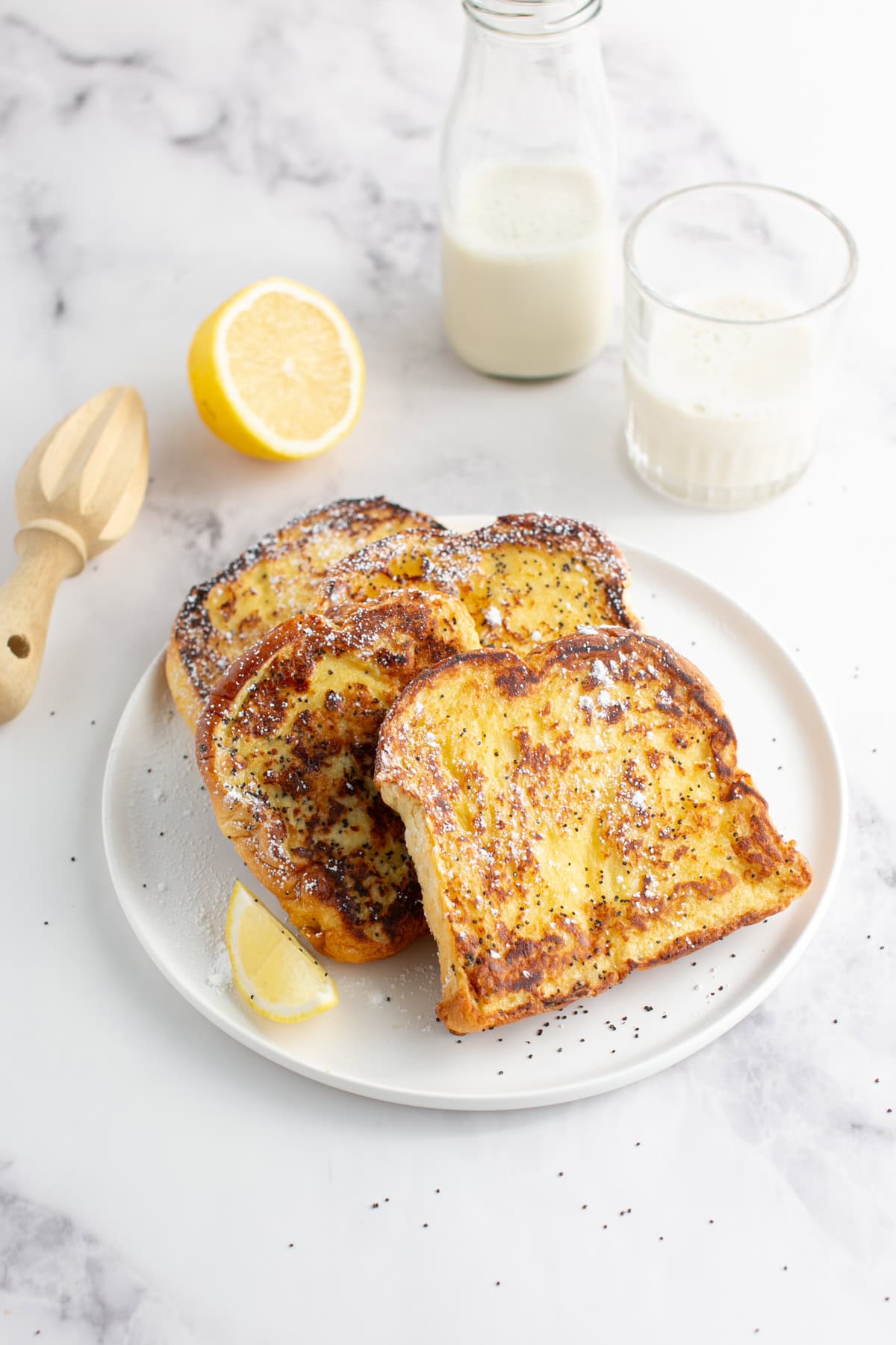 Lemon Poppy Seed Brioche French Toast with a cup of milk.