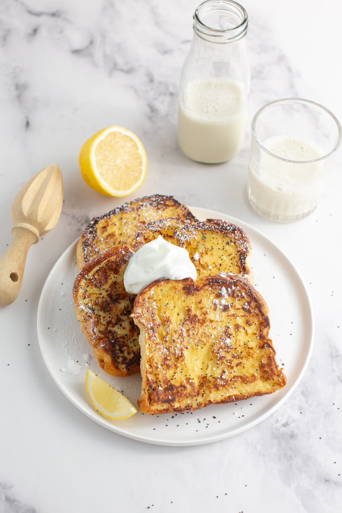 Lemon Poppy Seed Brioche French Toast with a dollop of whipped cream.