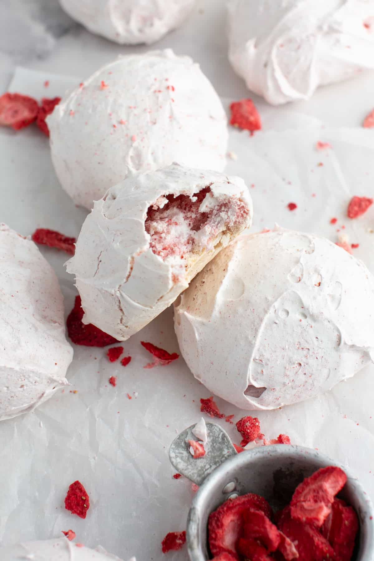 Strawberry Meringue Cloud Cookies with a bite missing.