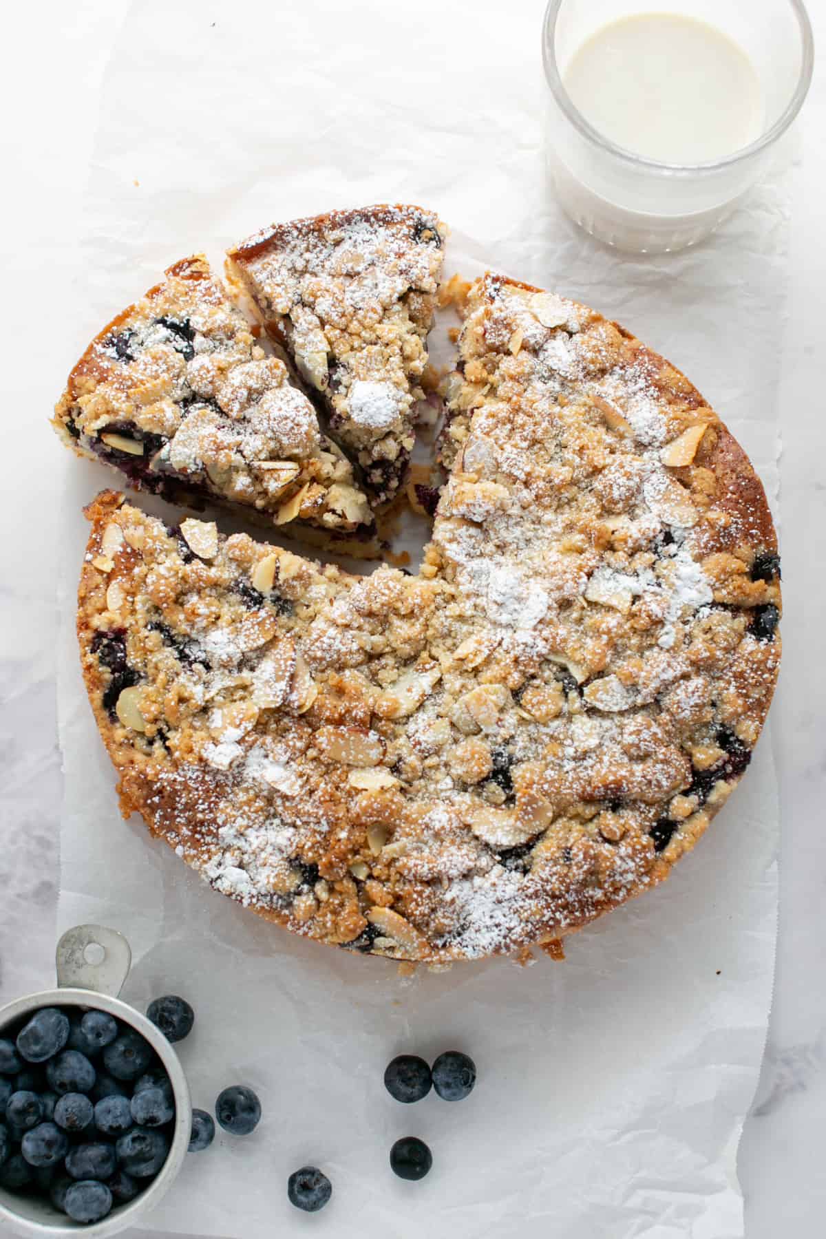 Blueberry Almond Crumble Cake by a glass of milk.