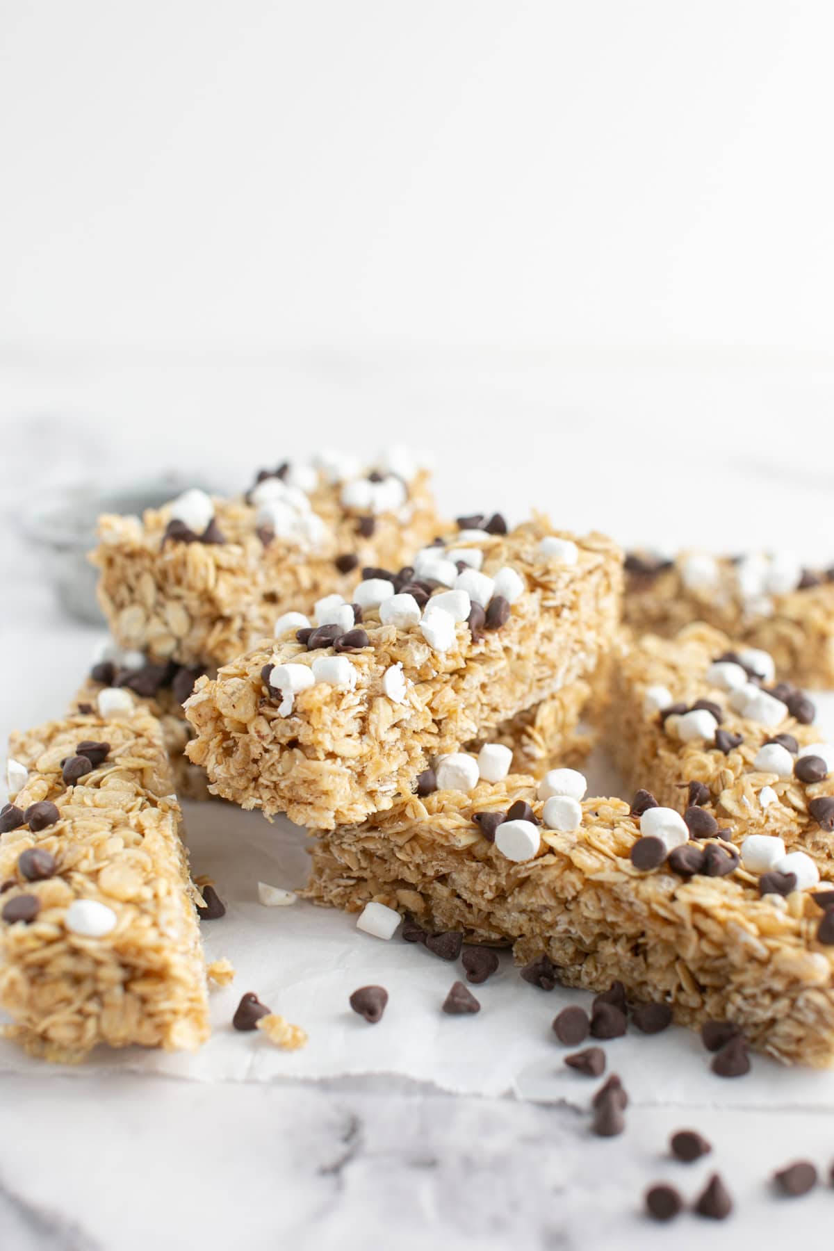 Chewy S’mores Granola Bars stacked on each other with chocolate chips.