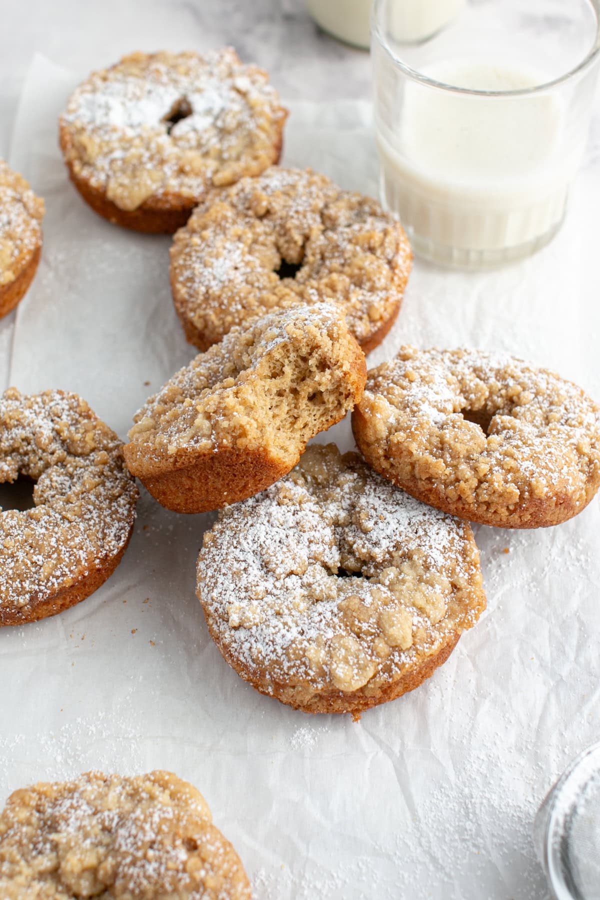 Cinnamon Sugar Crumble Donuts stacked on each other with a bite missing.