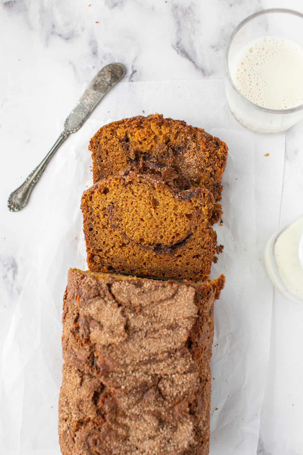 Pumpkin Maple Bread with Cinnamon Swirl Streusel sliced on parchment paper. 