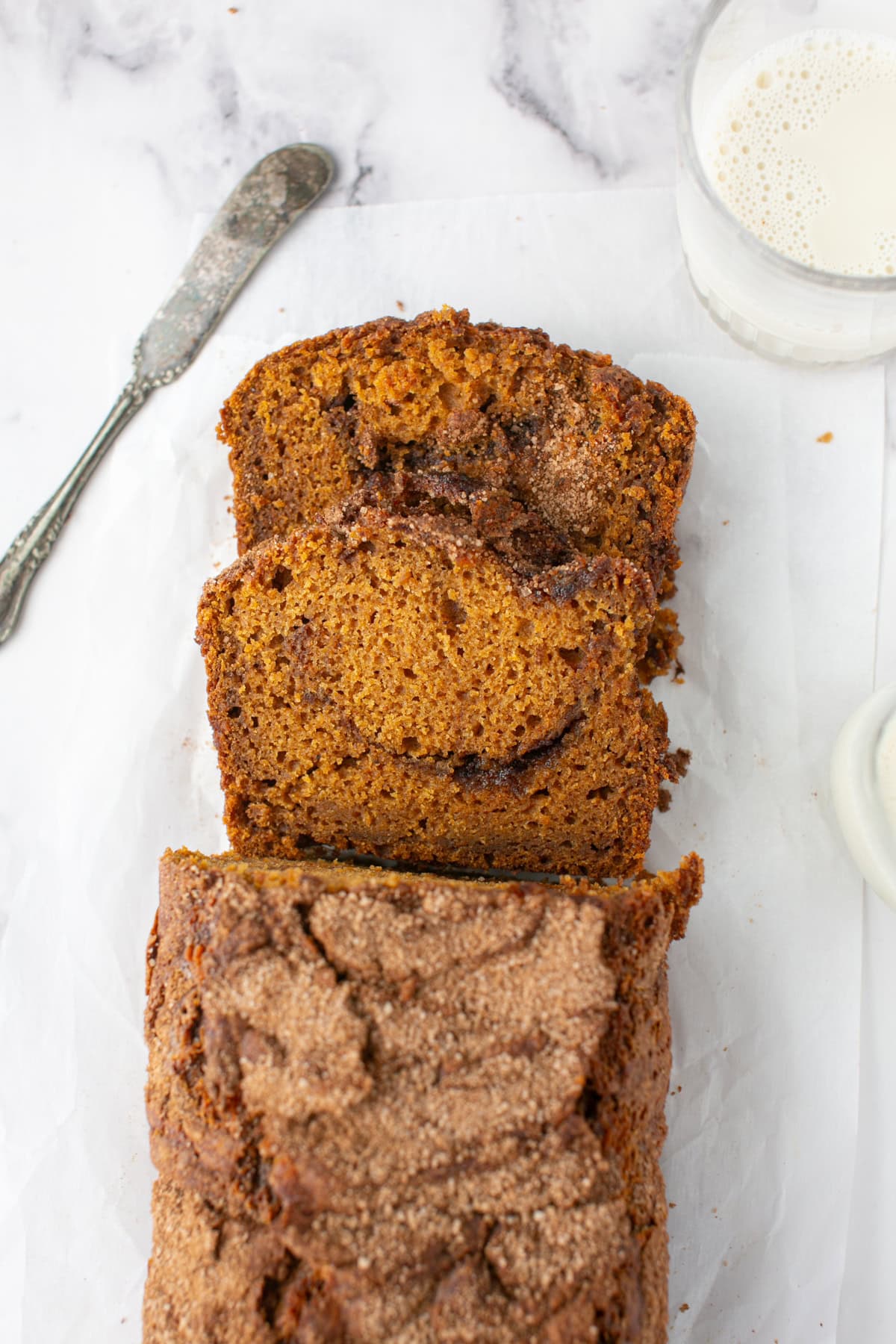 Pumpkin Maple Bread with Cinnamon Swirl Streusel sliced with a glass of milk.