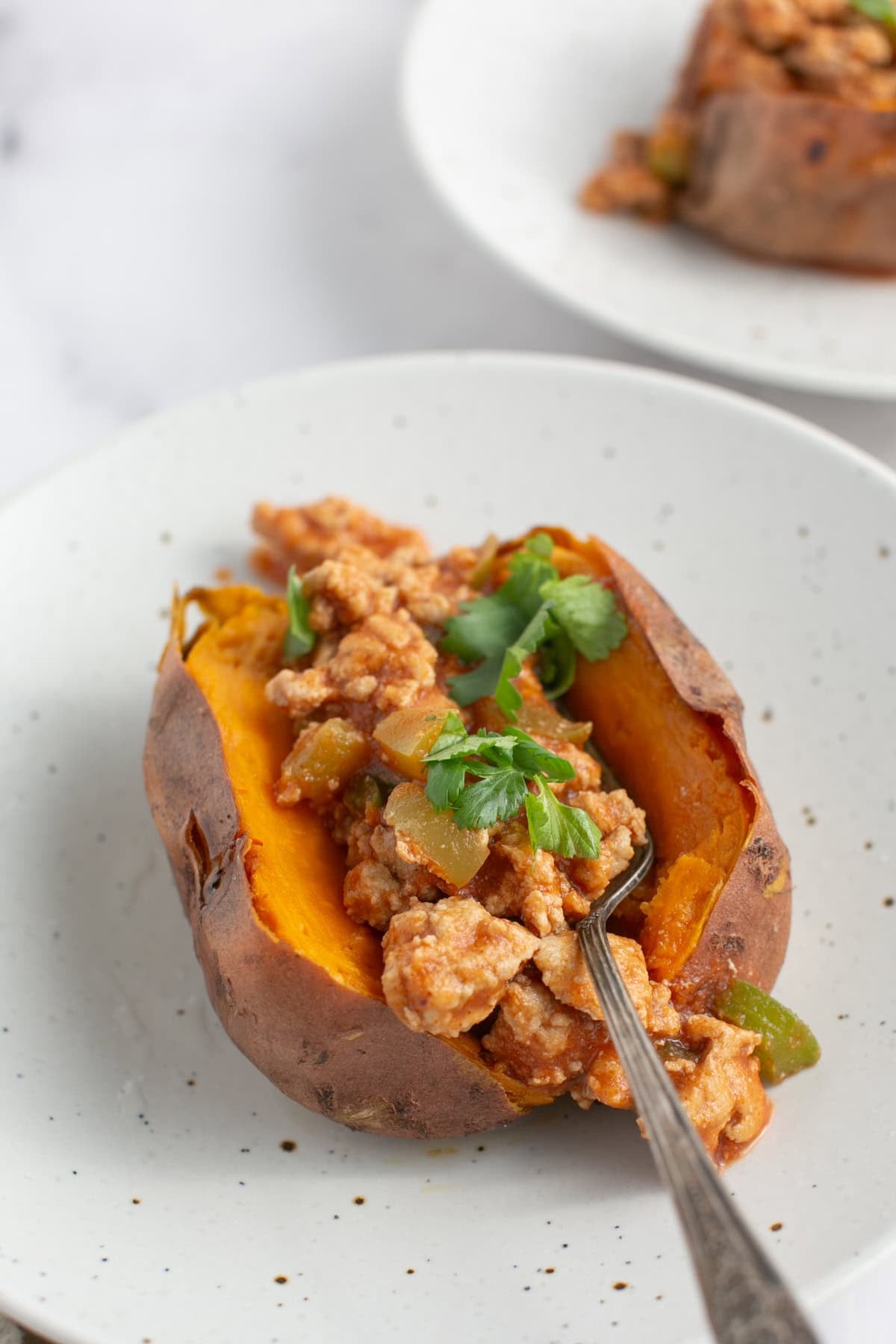 Sloppy Joe Stuffed Sweet Potatoes with fork scooping a bite.
