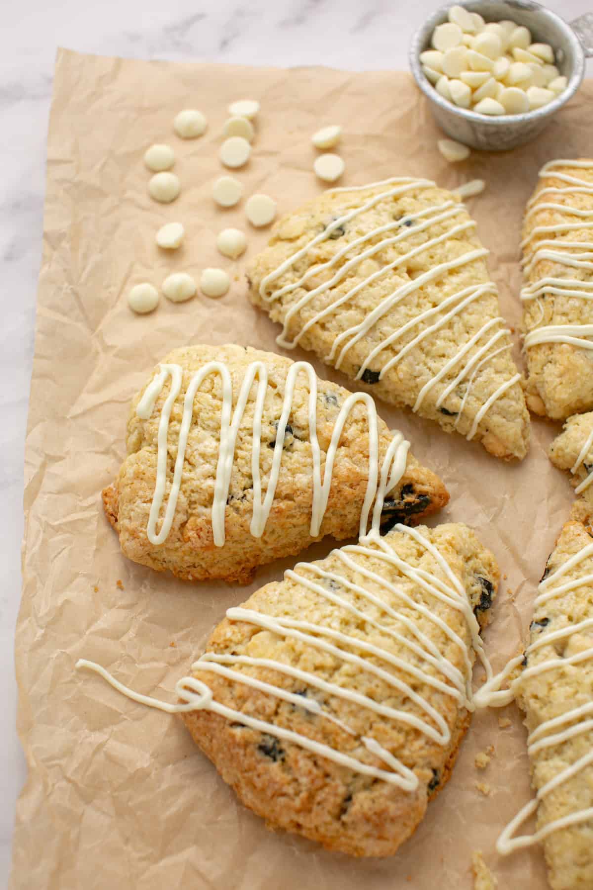 White Chocolate Chip Blueberry Scone by a bowl of white chocolate chips.