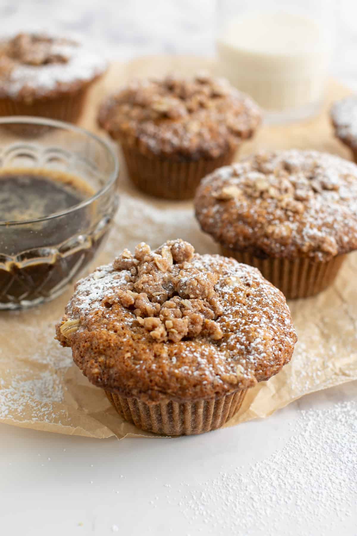 Chai Spiced Oat Crumble Muffins by a cup of coffee.