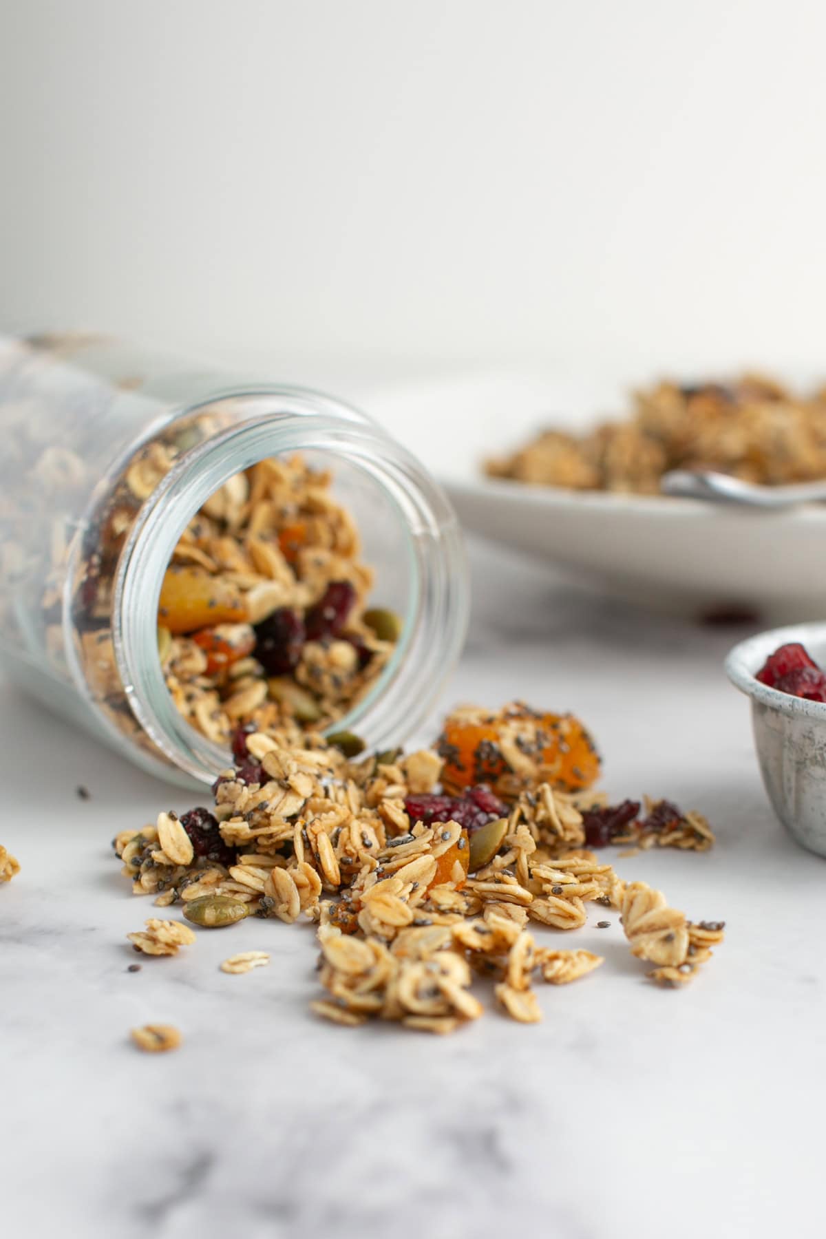 Maple Pumpkin Spice Granola pouring out of a jar.