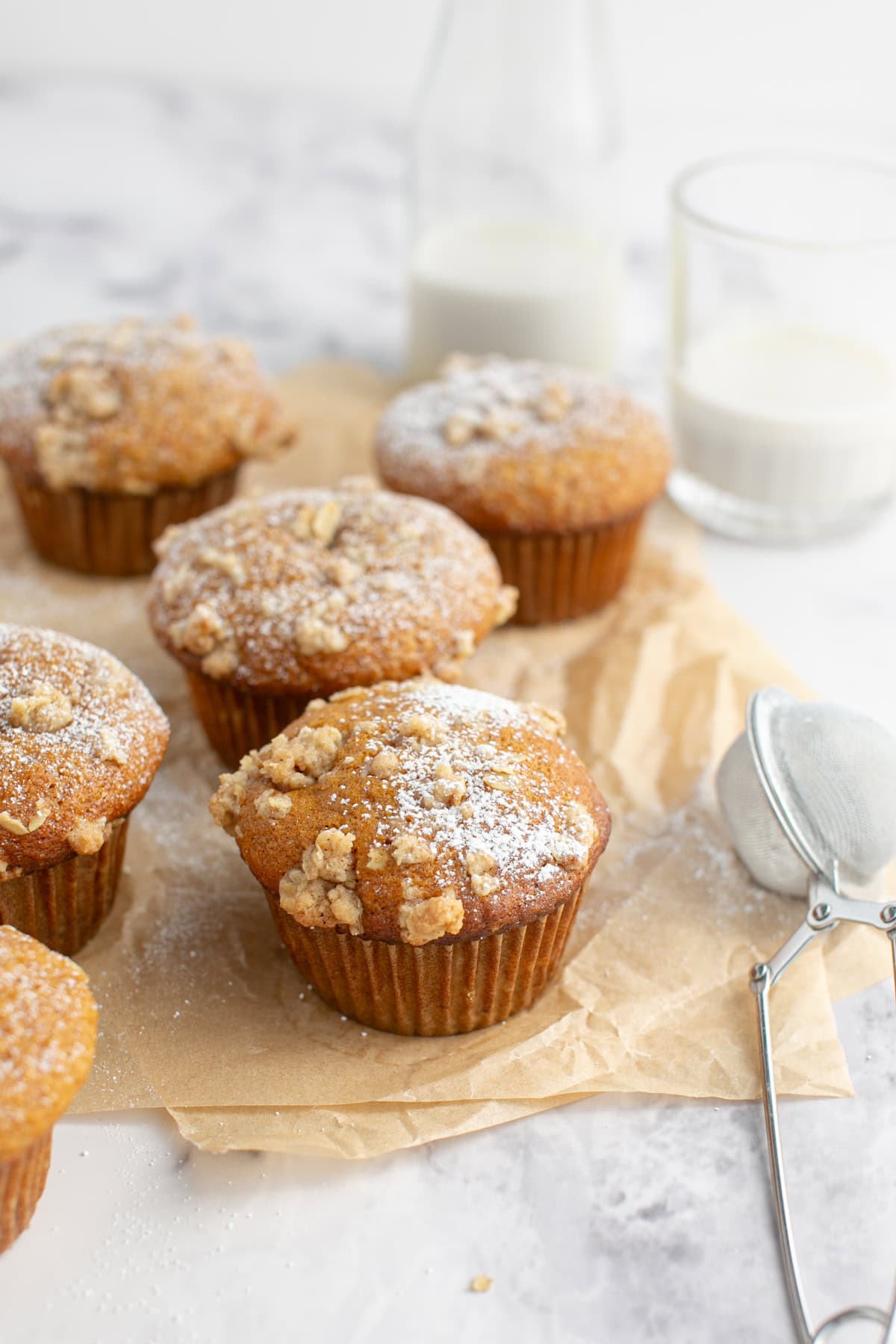 Cinnamon Maple Oat Pumpkin Muffin by a glass of milk.