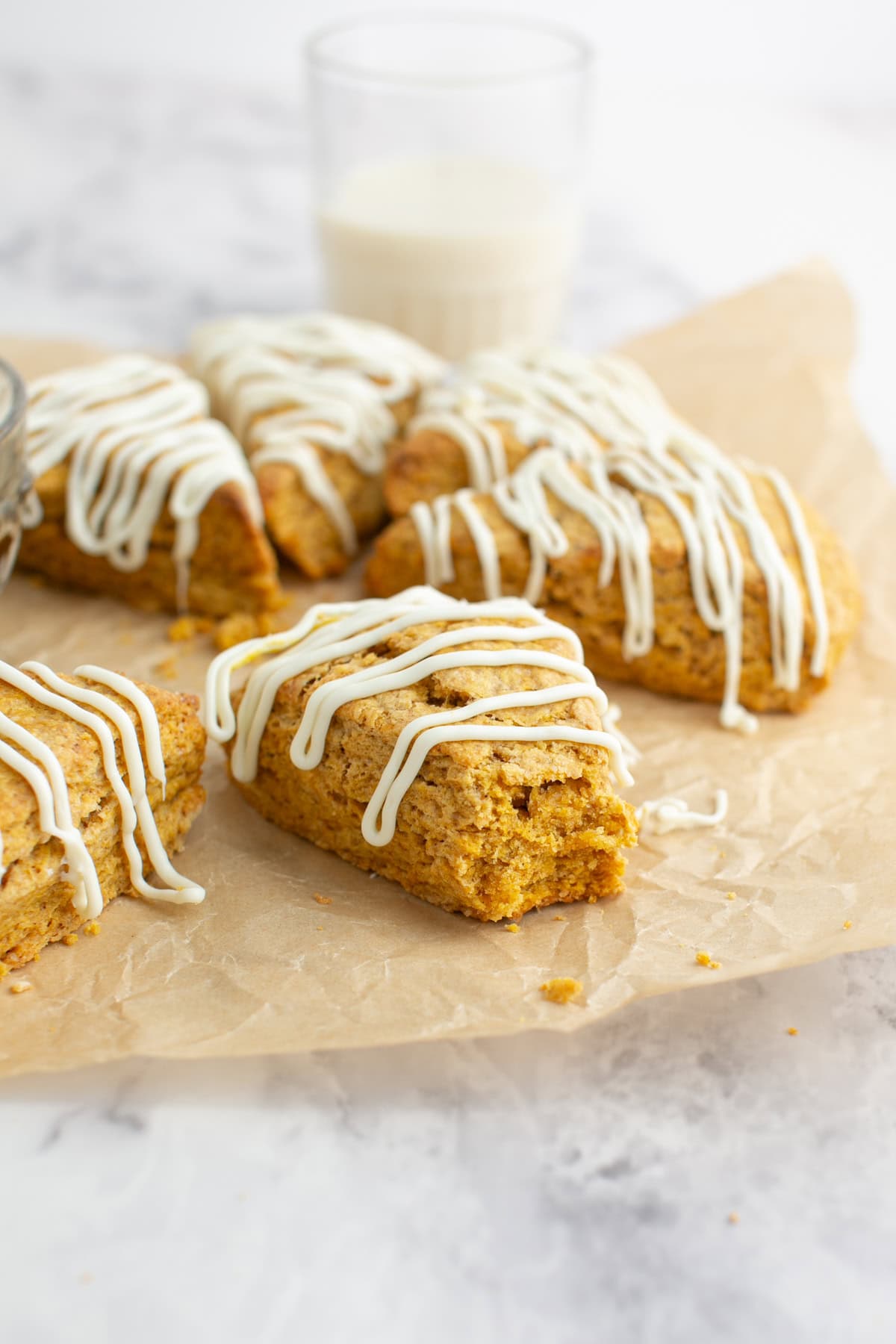Pumpkin Scones by a glass of milk with a bite missing.