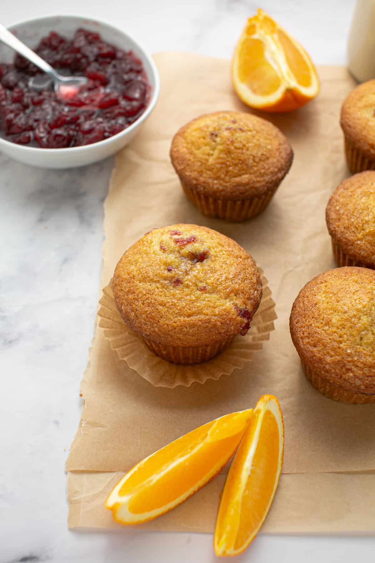 Cranberry Sauce Orange Muffins with a bowl of cranberry sauce.