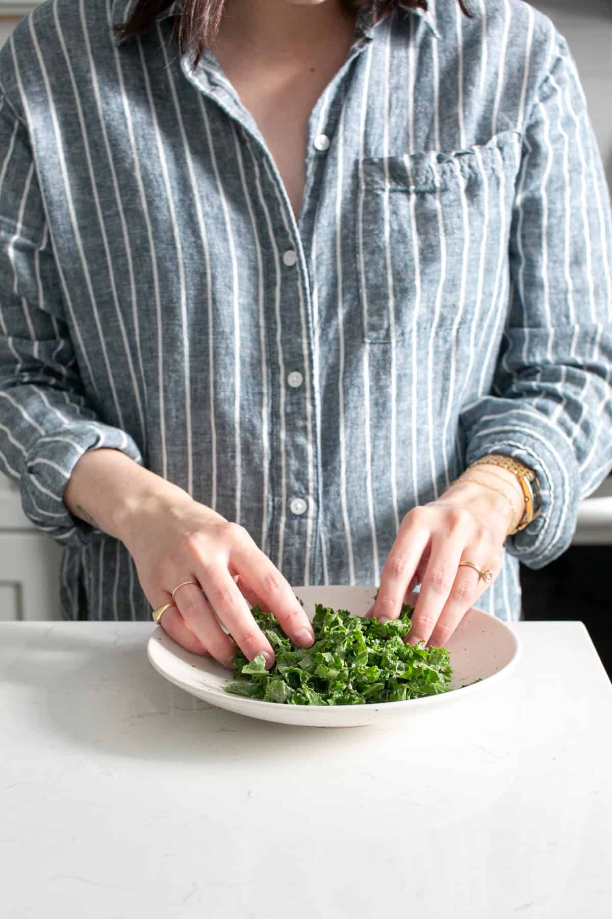Massaging kale caesar dressing.